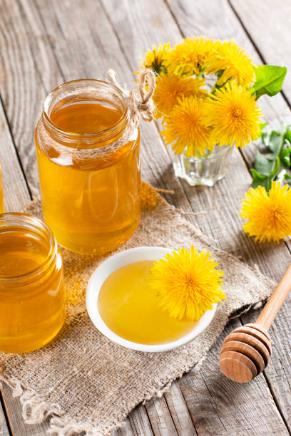 istock Dandelion honey in a jar and fresh flowers on a table 1371029154