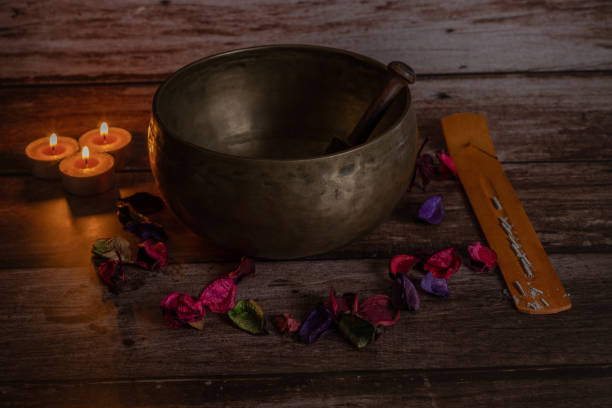 花びらとろうそくを持つチベットボウル - music wellbeing rin gong bowl ストックフォトと画像