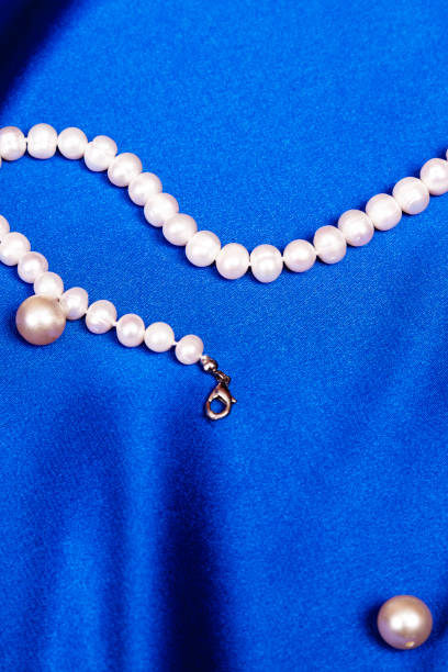 istock pearls beads on blue background. Gift for Valentine's Day. Preparing for Valentine's Day. vertical 1371036330