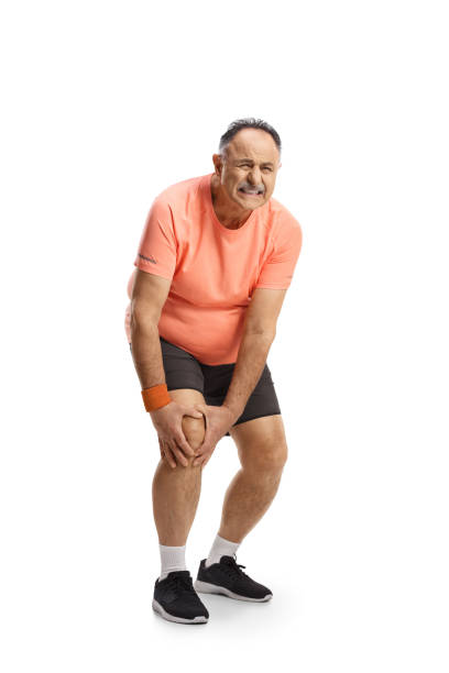 Full length portrait of a mature man in sportswear holding his painful knee Full length portrait of a mature man in sportswear holding his painful knee isolated on white background standing had to knee pose stock pictures, royalty-free photos & images