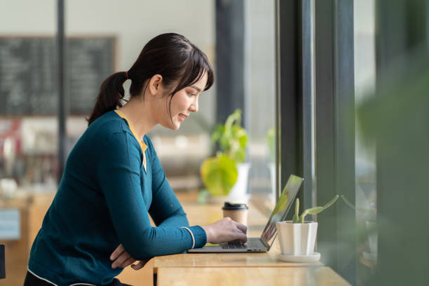 istock Pretty female student with cute smile keyboarding something on laptop while relaxing after lectures in University, beautiful happy woman working on laptop computer during coffee break in cafe bar. 1371037445