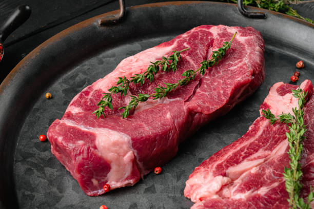 istock Chuck roll steak, on black wooden table background 1371038936