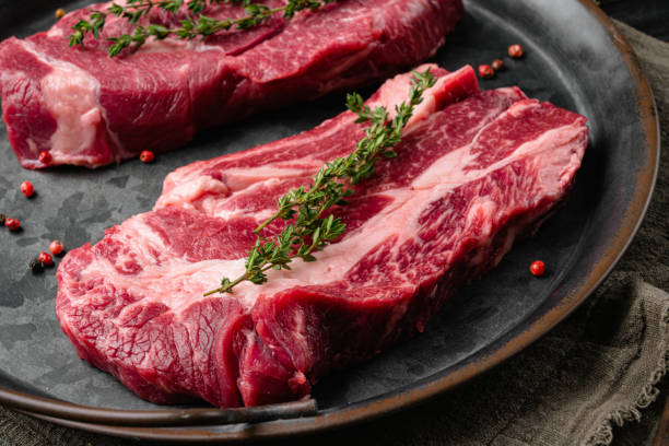 istock Raw meat steaks, on old dark  wooden table background 1371039040