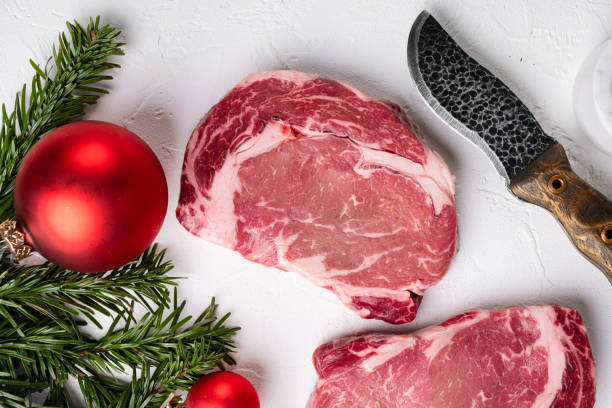 크리스마스 트리 장식이있는 고전적인 신선한 갈비 눈 스테이크, 흰색 돌 테이블 배경, 상단 보기 플랫 레이 - steak strip steak ribeye sirloin steak 뉴스 사진 이미지