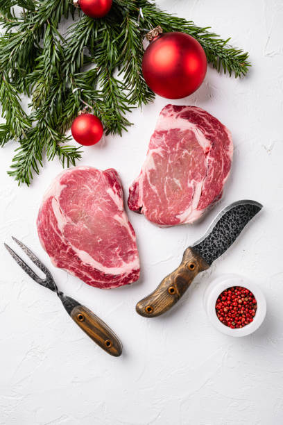 steak de bœuf cru pour la nouvelle année, sur fond de table en pierre blanche, vue du dessus à plat, avec espace de copie pour le texte - strip steak steak sirloin steak rib eye steak photos et images de collection