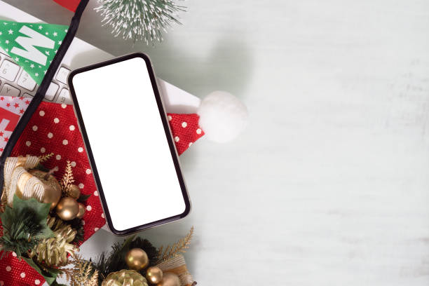 istock Mockup blank white screen smartphone on home office desk with computer keyboard on white background for Christmas and New Year, Flat lay top view with copy space for Christmas and  New year artwork. 1371042617