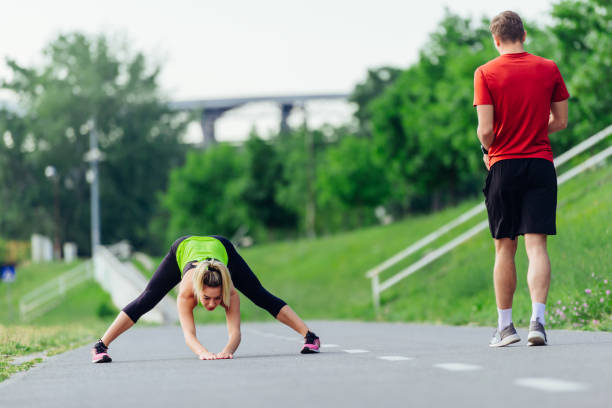 istock Young couple  warming up and stretching together in a park before running 1371043596