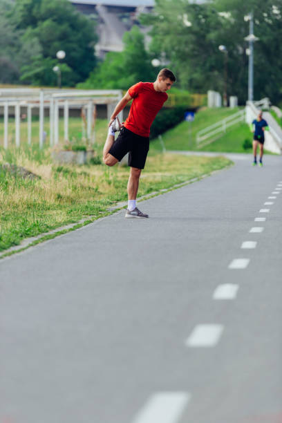 istock Handsome young man stretching and warming up before for morning workout  in the park 1371043604