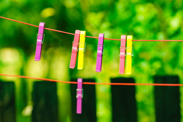 Clips for washing laundry clothes pegs on string rope outdoor. Housework concept