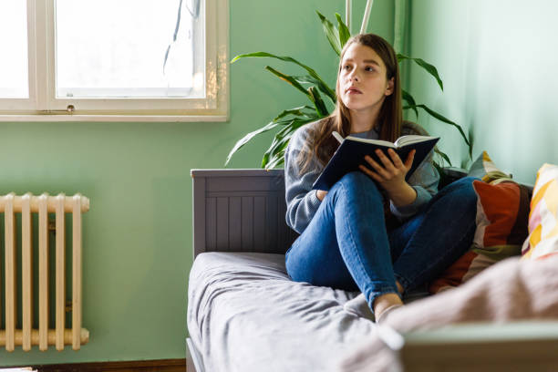 istock Young woman contemplating what to write in a diary 1371044938
