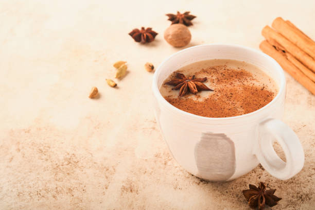 istock Masala tea. Masala chai spiced tea with milk and spices on light warm beige background. Traditional indian drink. Copy space. Selective focus. 1371046607