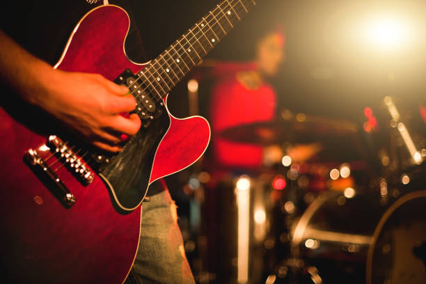 chitarrista indie rock che suona la chitarra in uno spettacolo dal vivo con luci sul palco - chitarrista foto e immagini stock