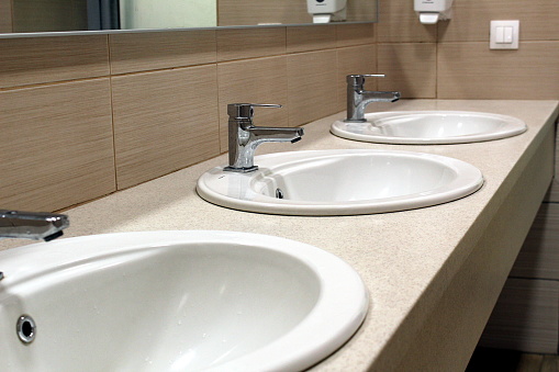 Three white sinks in the toilet room