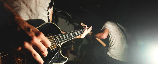 gitarzysta hard rock grający na gitarze w koncercie na żywo ze światłami scenicznymi - modern rock zdjęcia i obrazy z banku zdjęć