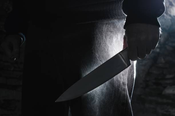 Dark photo of a man holding a big knife, crime concept. Dark photo of a man holding a big knife, crime concept. assassination photos stock pictures, royalty-free photos & images