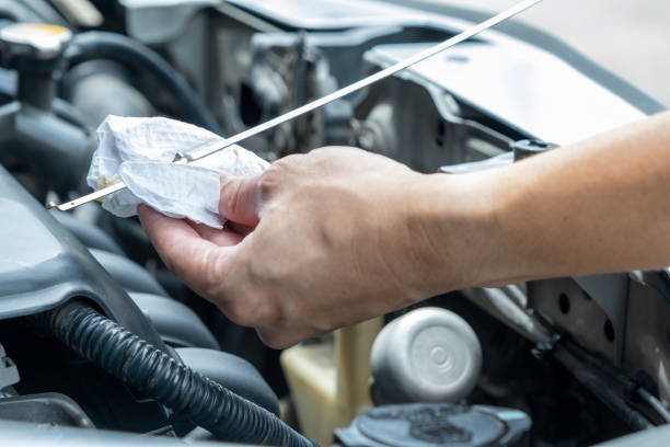 Man's hand checking the engine oil level by himself