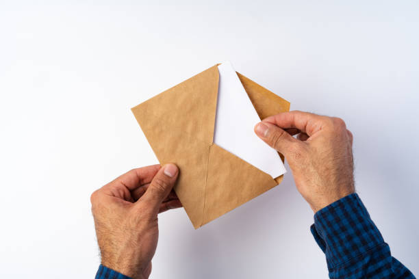 istock Top view of male hands hold (open) an envelope above white background 1371049984