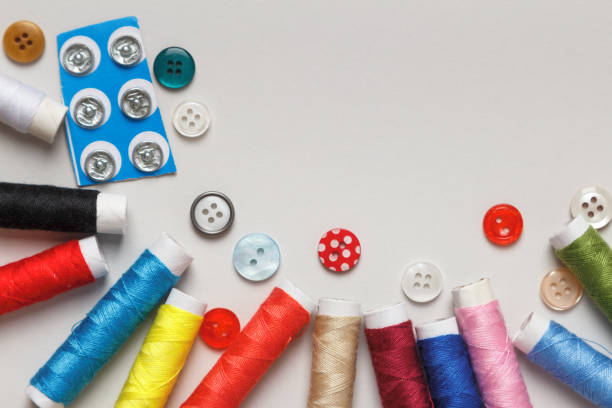 istock Multi-colored spools of thread with buttons on the table. Flat lay closeup with copy space. 1371050133