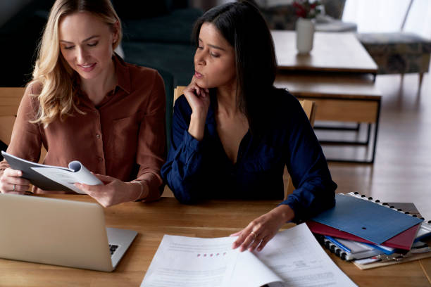 istock Two adult woman analyzing document at home office 1371051171