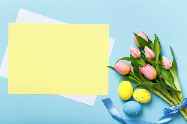 istock Easter composition. Eggs flowers tulips on a blue background. Empty sheet of paper with space for text and copy space 1371051889