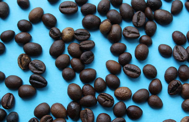 istock Roasted coffee beans lie on a blue background 1371054523