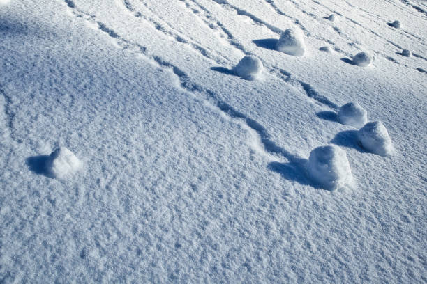 丘の中腹の冬の柔らかい雪の表面パターン - 雪玉 ストックフォトと画像
