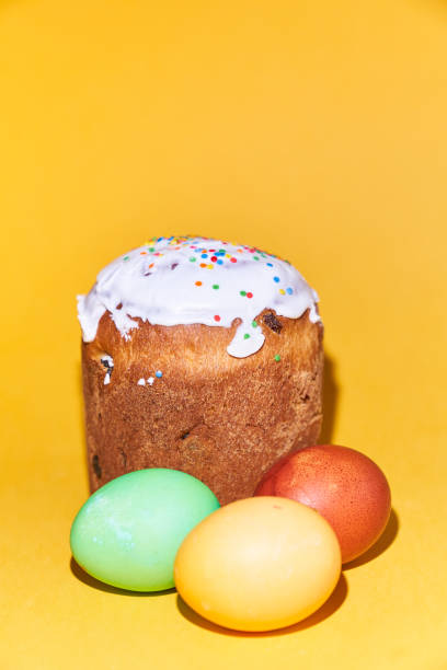 istock Close-up of colored Easter eggs and a cake on a yellow background. With space to copy 1371054777