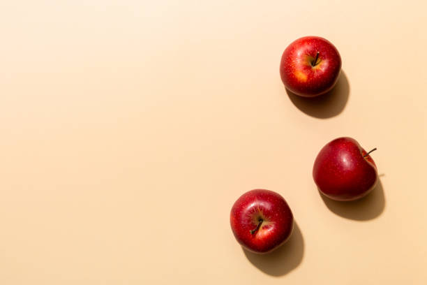 istock Many red apples on colored background, top view. Autumn pattern with fresh apple above view with copy space for design or text 1371058404