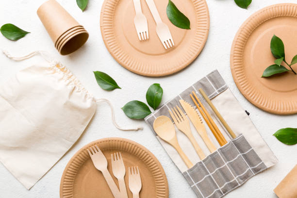 istock set of empty reusable disposable eco-friendly plates, cups, utensils on light white colored table background. top view. Biodegradable craft dishes. Recycling concept. Close-up 1371058442