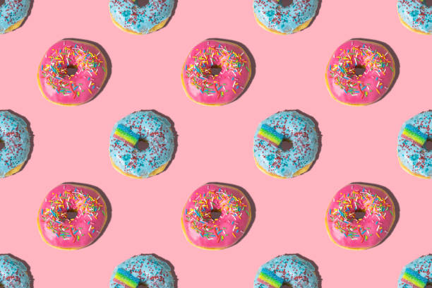istock Repeating pattern of pink and blue donuts on a pink background. Flat lay 1371059964