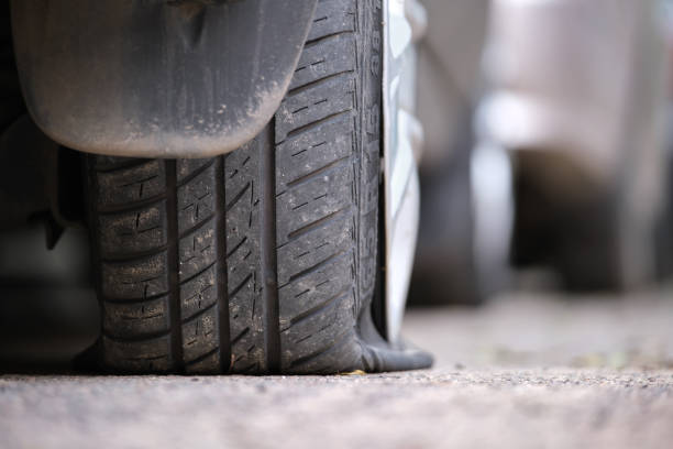 istock Car with punctured flat tire parked on roadside 1371060032