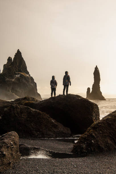istock Two women watching at the Reynisdrangar at the sunset 1371061035