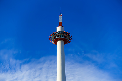 On a sunny day in September 2017, the Kyoto Tower towering from the front of JR Kyoto Station to the end of the bus terminal is a white tower designed in Japanese style against the blue sky.