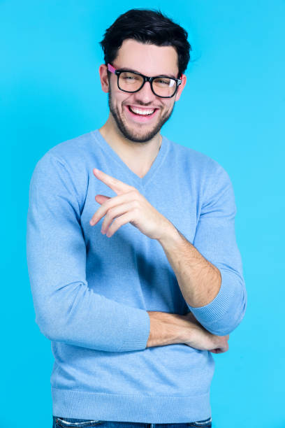 istock Smiling Laughing Positive Confident Caucasian Handsome Brunet Man With Folded Hands While Looking Straight To Side Against Blue Background. 1371063334
