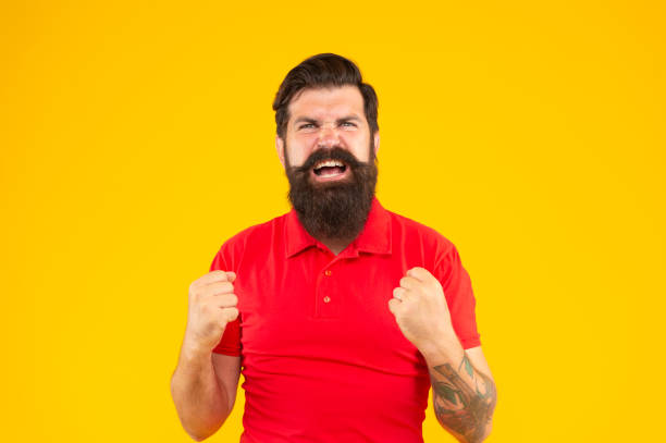 istock aggressive hipster male with beard on yellow background, anger 1371064504