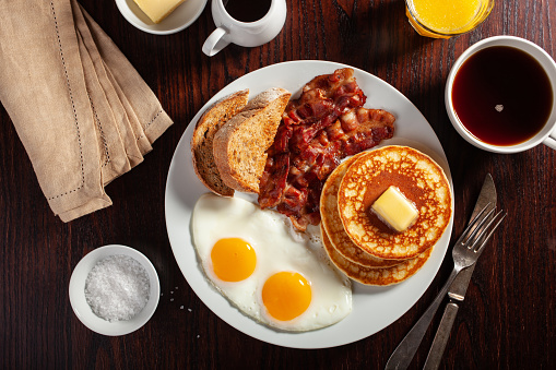 panqueques tradicionales de desayuno americano completo con tocino y tostadas photo