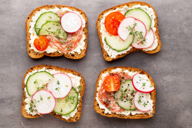 istock Sandwich with cereals bread and salami on dark marble background. 1371066646