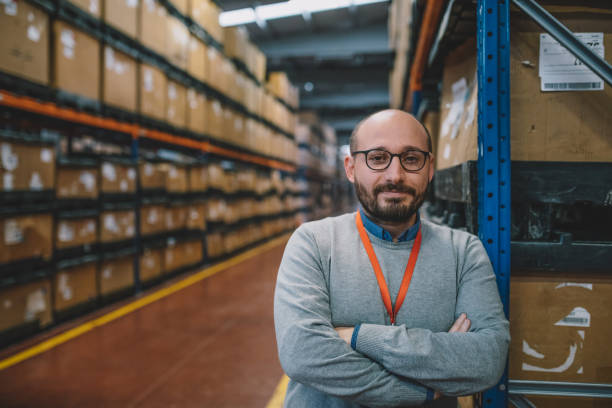 retrato de um empresário parado no corredor do armazém - warehouse manager place of work portrait - fotografias e filmes do acervo