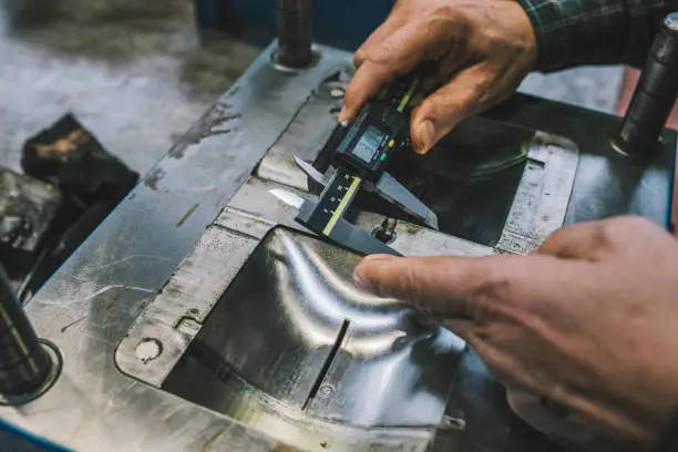 Photo of Lathe worker man working with a vernier and milling machine in a factory