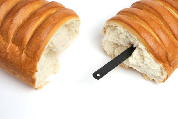 Loaf loaf broken in half, with hacksaw for metal inside.Tool, concept and symbol of prison escape.On white background