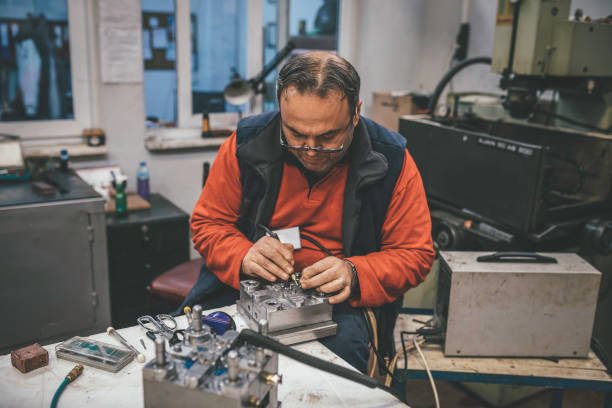 trabalhador técnico profissional trabalhando e testando corrente elétrica em uma fábrica - cnc vehicle part quality control industry - fotografias e filmes do acervo