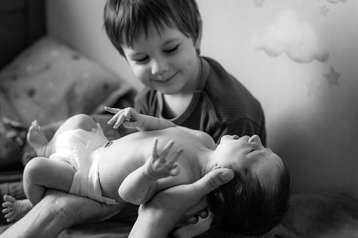 Happy boy meeting his newborn sister