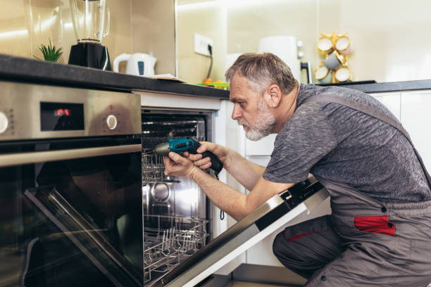 istock Man with toolbox repairing dishwasher in a household. 1371072465