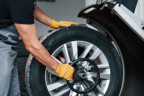 istock Taking the wheel. Man in uniform is working in the auto service 1371073068