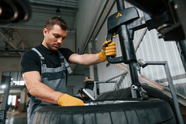 istock Strong hands. Man in uniform is working in the auto service 1371073130