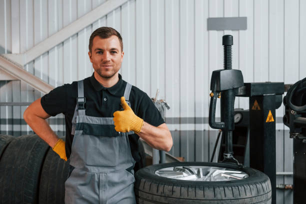 istock Broken wheel. Man in uniform is working in the auto service 1371073668