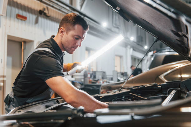 istock Ready to solve the problem. Man in uniform is working in the auto service 1371074059