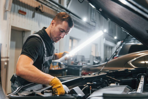istock Ready to solve the problem. Man in uniform is working in the auto service 1371074073