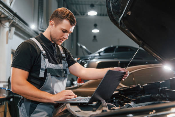 istock Side view. Man in uniform is working in the auto service 1371074136