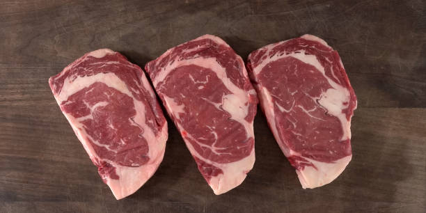 istock Thick cut raw beef eibeye with bone for roast. raw cowboy steak. seasoning and meat fork 1371075637